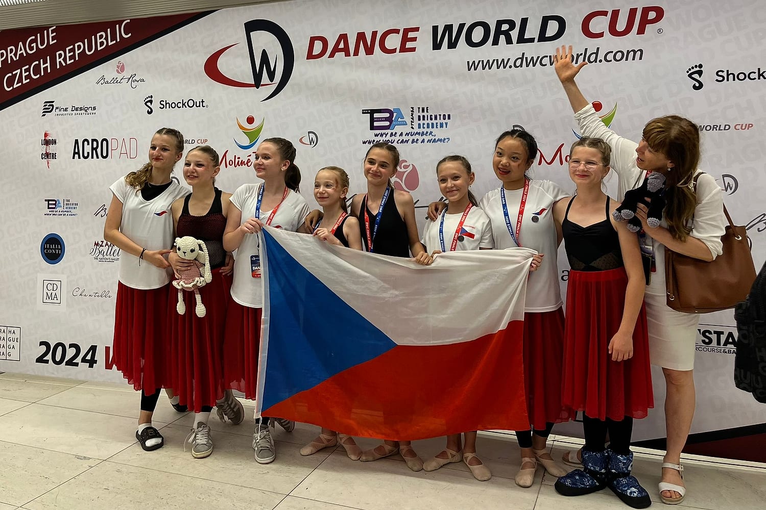 Tým Arabesky s českou vlajkou a medailemi na Dance World Cup v Praze